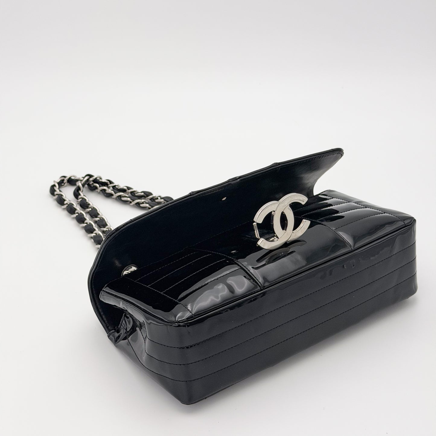 Second hand Chanel patent leather flap bag, vertical stitch detail, silver CC turnlock close-up