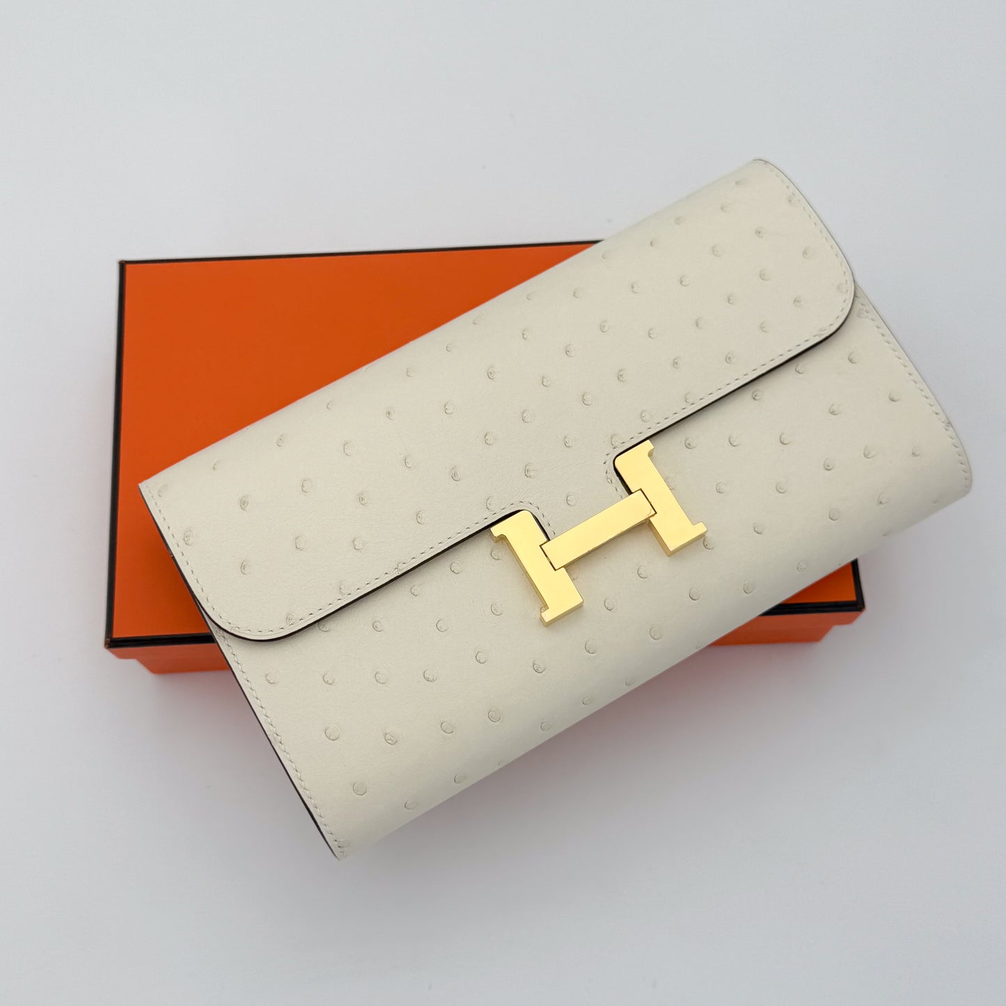 Brand New Hermes Constance To Go in Ostrich Nata with gold tone hardware onto of orange Hermes box
