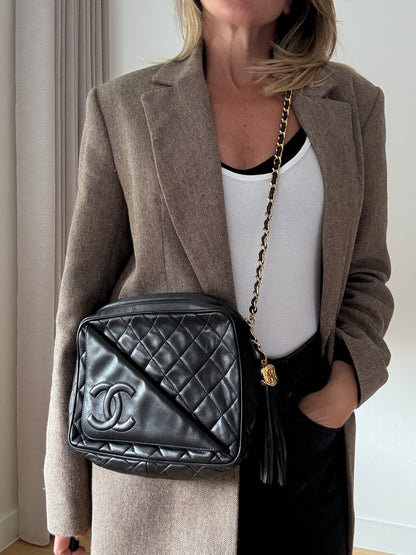 Vintage Chanel black quilted lambskin tassel camera bag front view with gold chain and CC logo on model