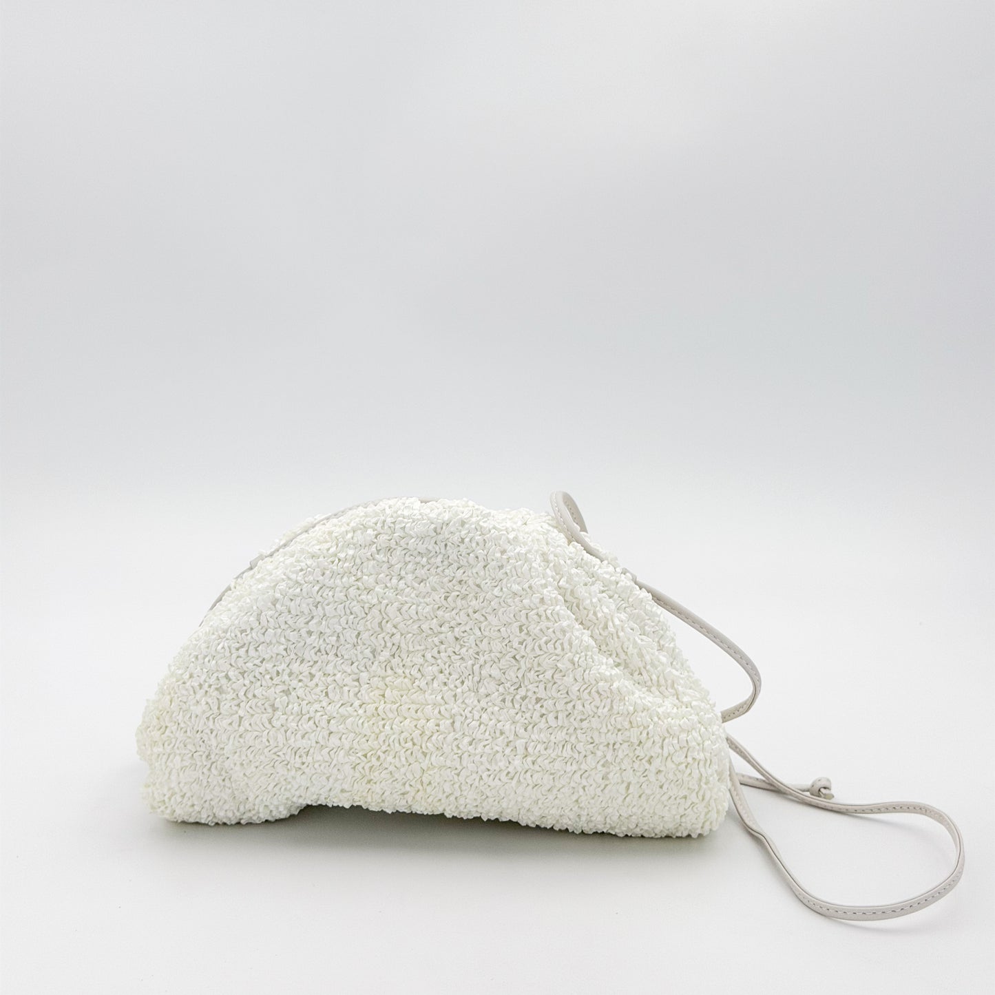 Bottega Veneta raffia pouch front view showing texture and strap