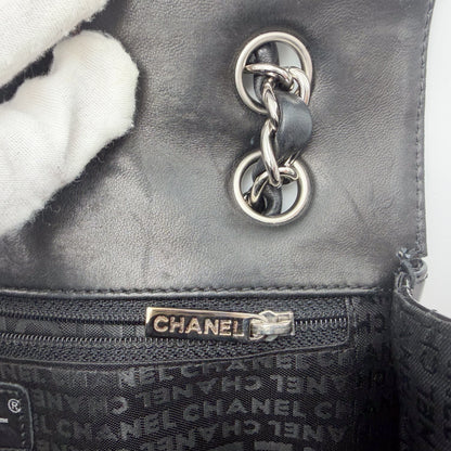 Vintage Chanel flap bag zipper pull branding and leather interior detail, silver hardware