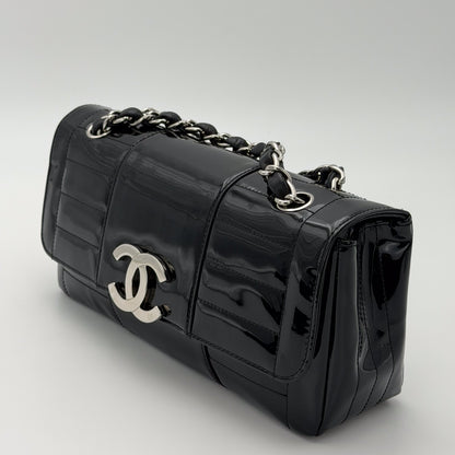 Chanel vertical stitch black patent flap bag, silver hardware, three-quarter side angle
