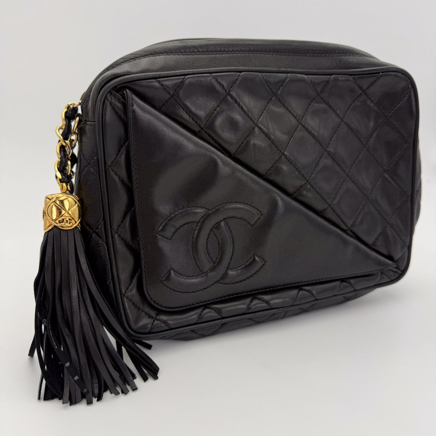 Vintage Chanel black quilted lambskin tassel camera bag front view with gold chain and CC logo