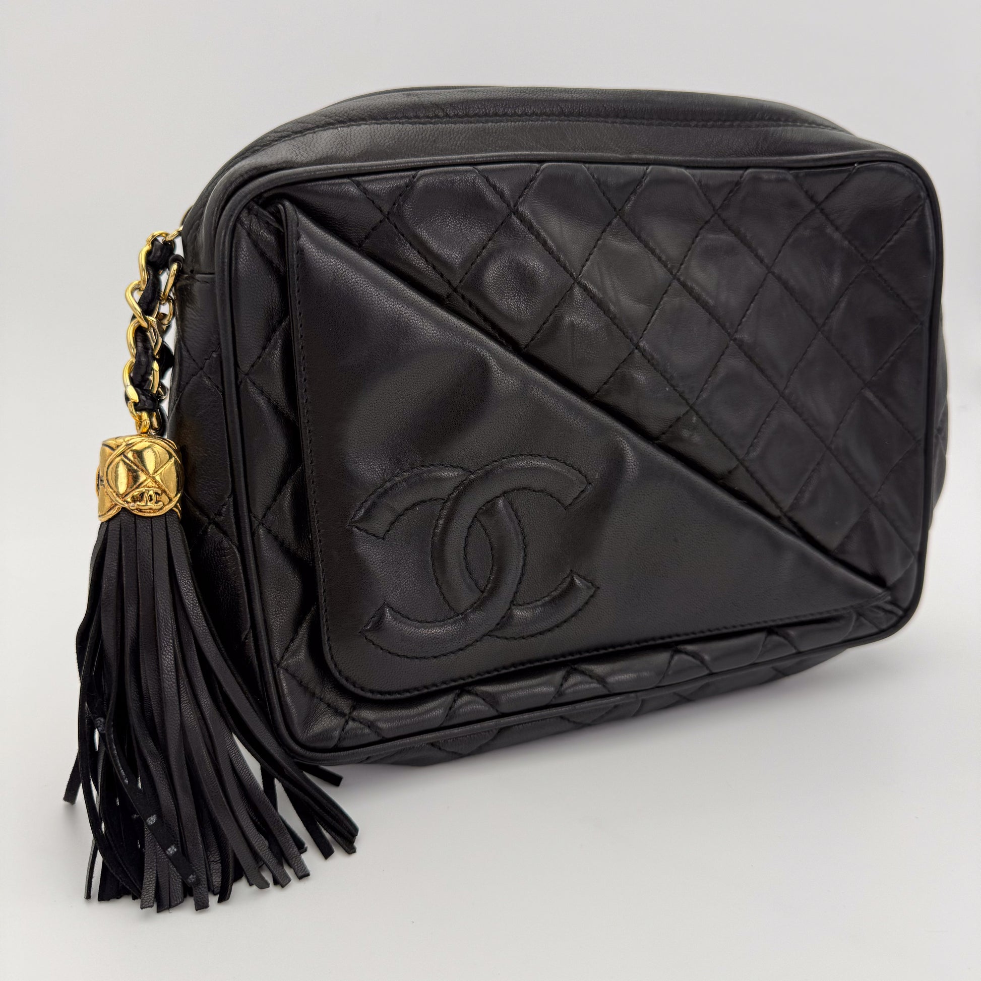 Vintage Chanel black quilted lambskin tassel camera bag front view with gold chain and CC logo