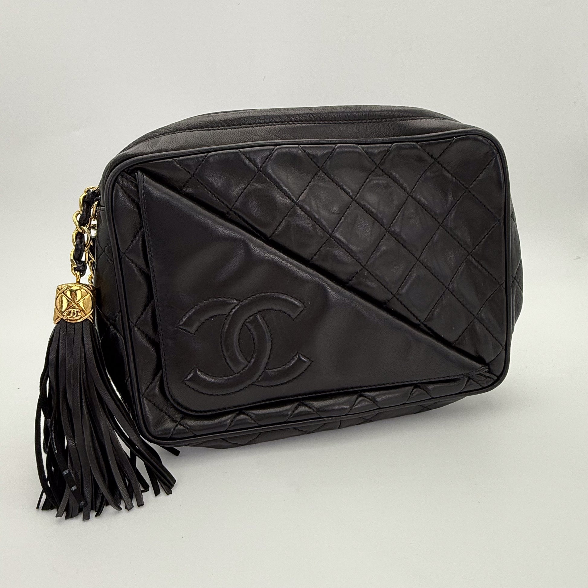 Vintage Chanel black quilted lambskin tassel camera bag front view with gold chain and CC logo