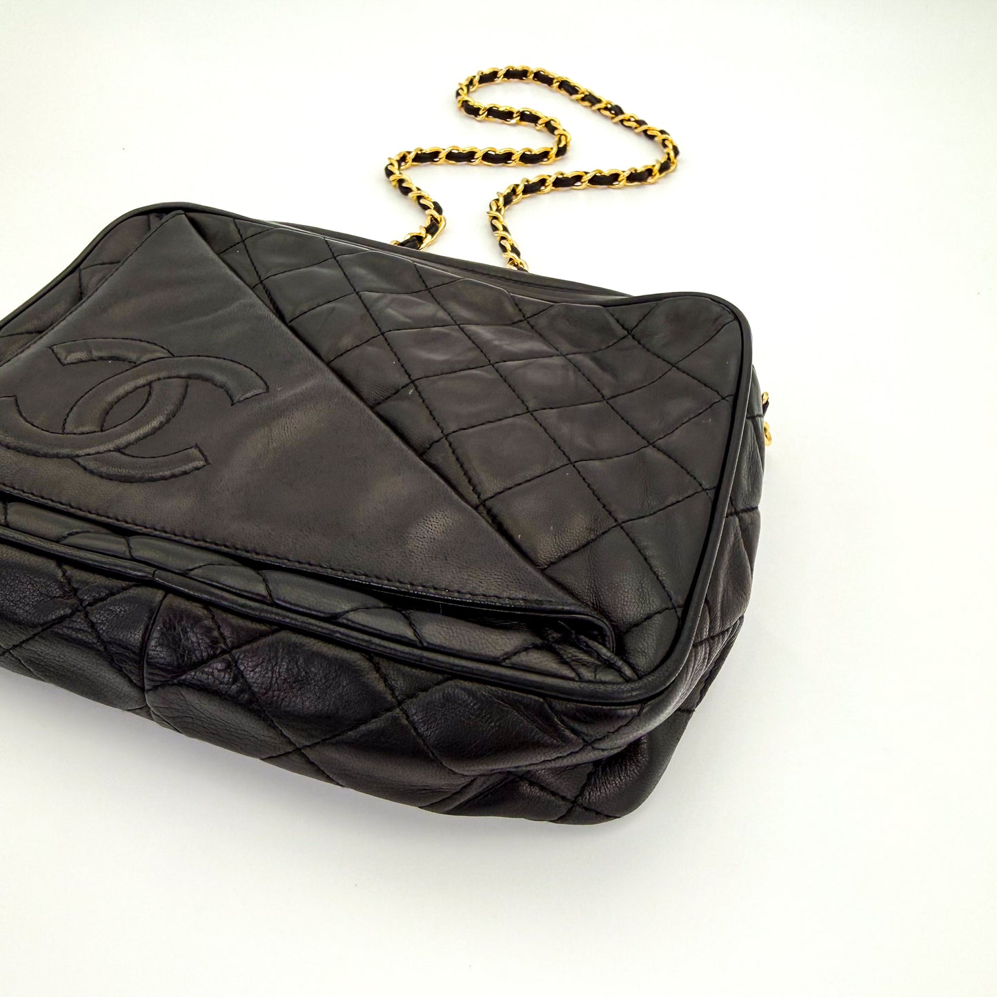 Vintage Chanel black quilted lambskin tassel camera bag front view with gold chain and CC logo with bottom view