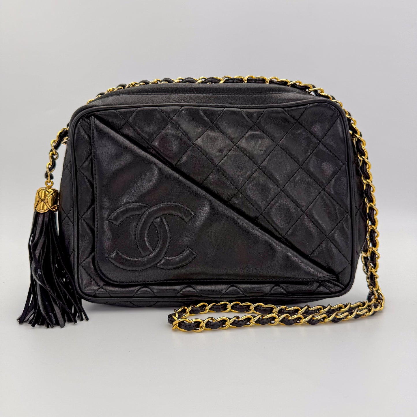Vintage Chanel black quilted lambskin tassel camera bag front view with gold chain and CC logo