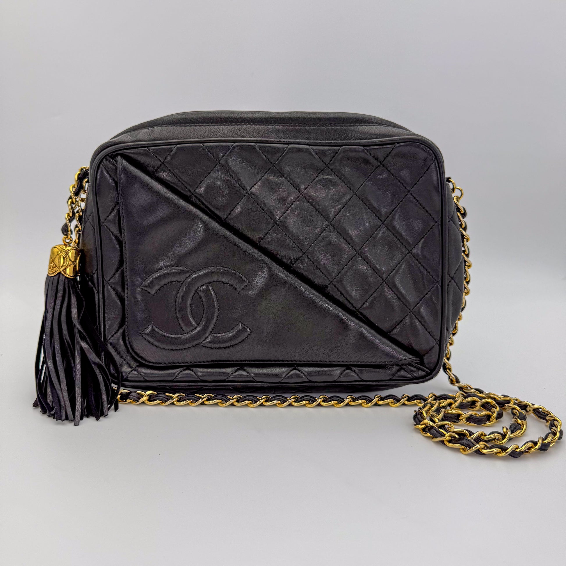 Secondhand Chanel black quilted lambskin tassel camera bag front view with gold chain and CC logo