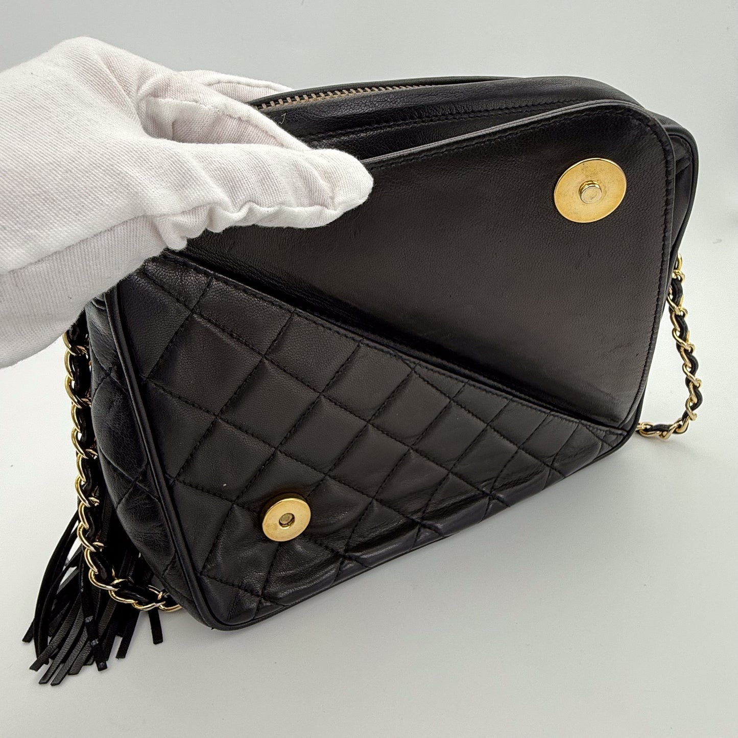 Vintage Chanel black quilted lambskin tassel camera bag front view with gold chain showing the front small pocket