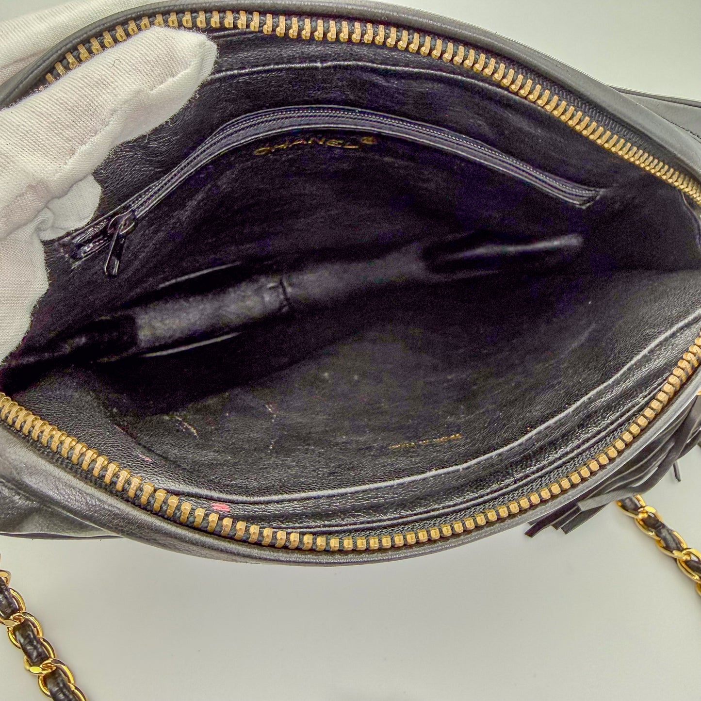Interior view of a preloved Chanel black quilted lambskin tassel camera bag in vintage condition