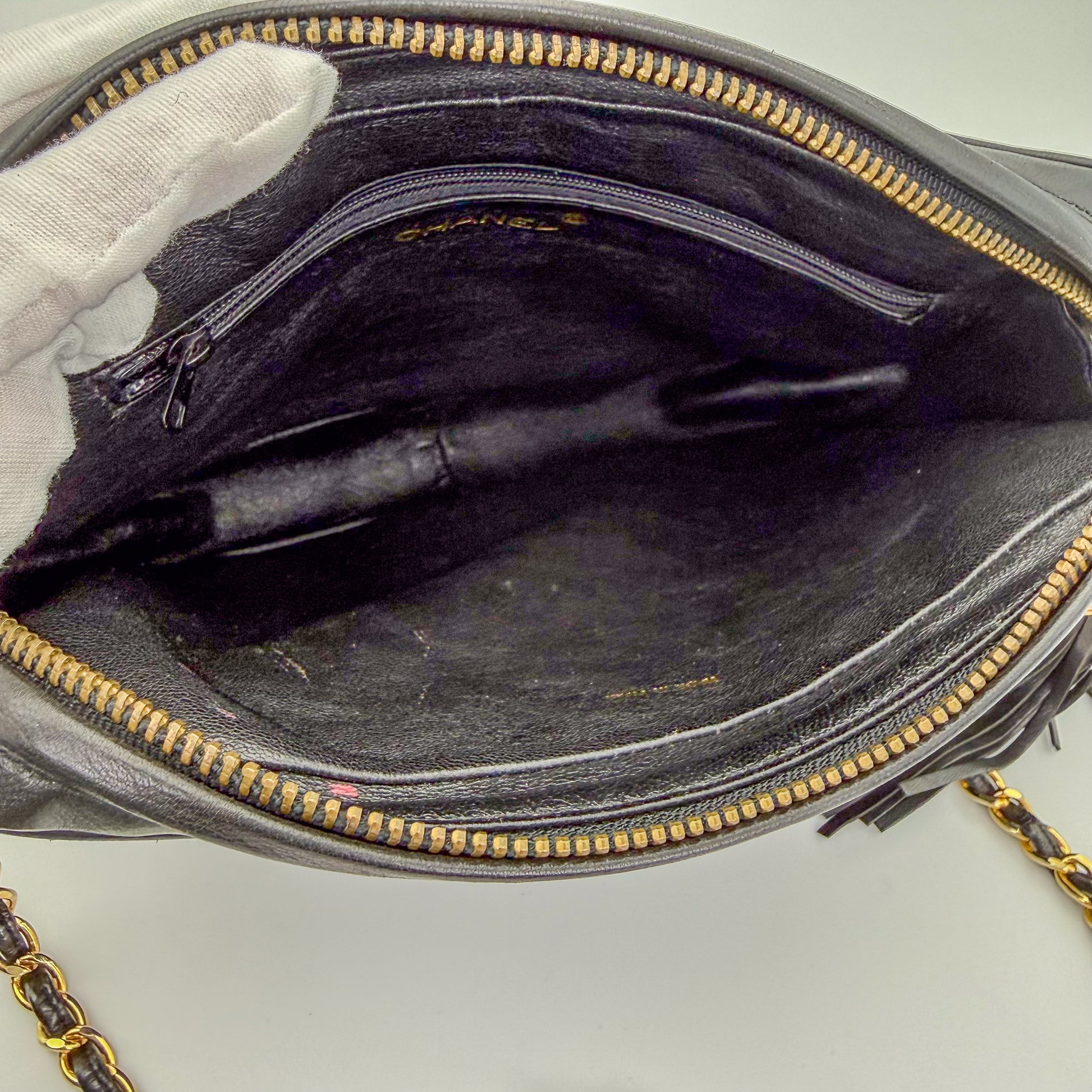 Interior view of a preloved Chanel black quilted lambskin tassel camera bag in vintage condition