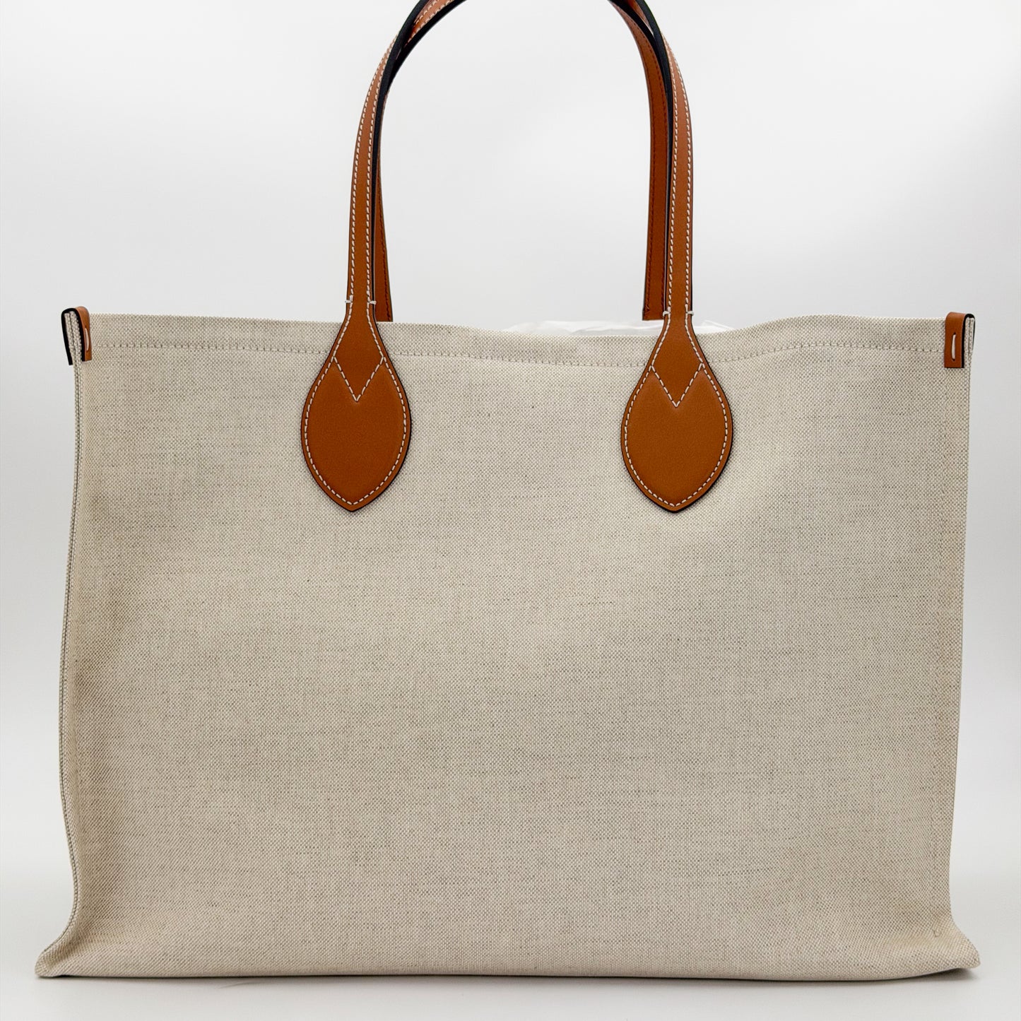 Brand new Gucci canvas tote back view showing natural canvas and leather handles