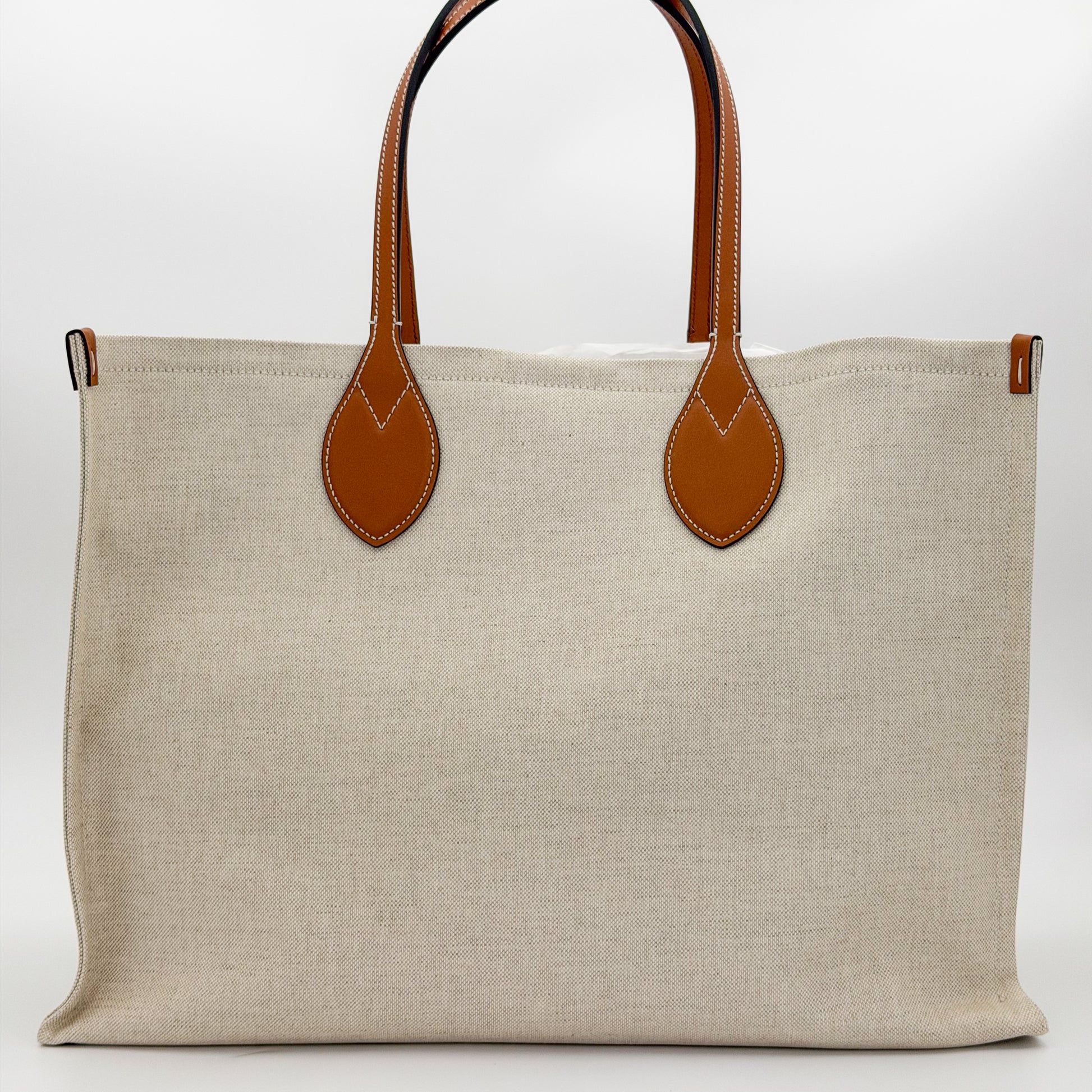 Brand new Gucci canvas tote back view showing natural canvas and leather handles