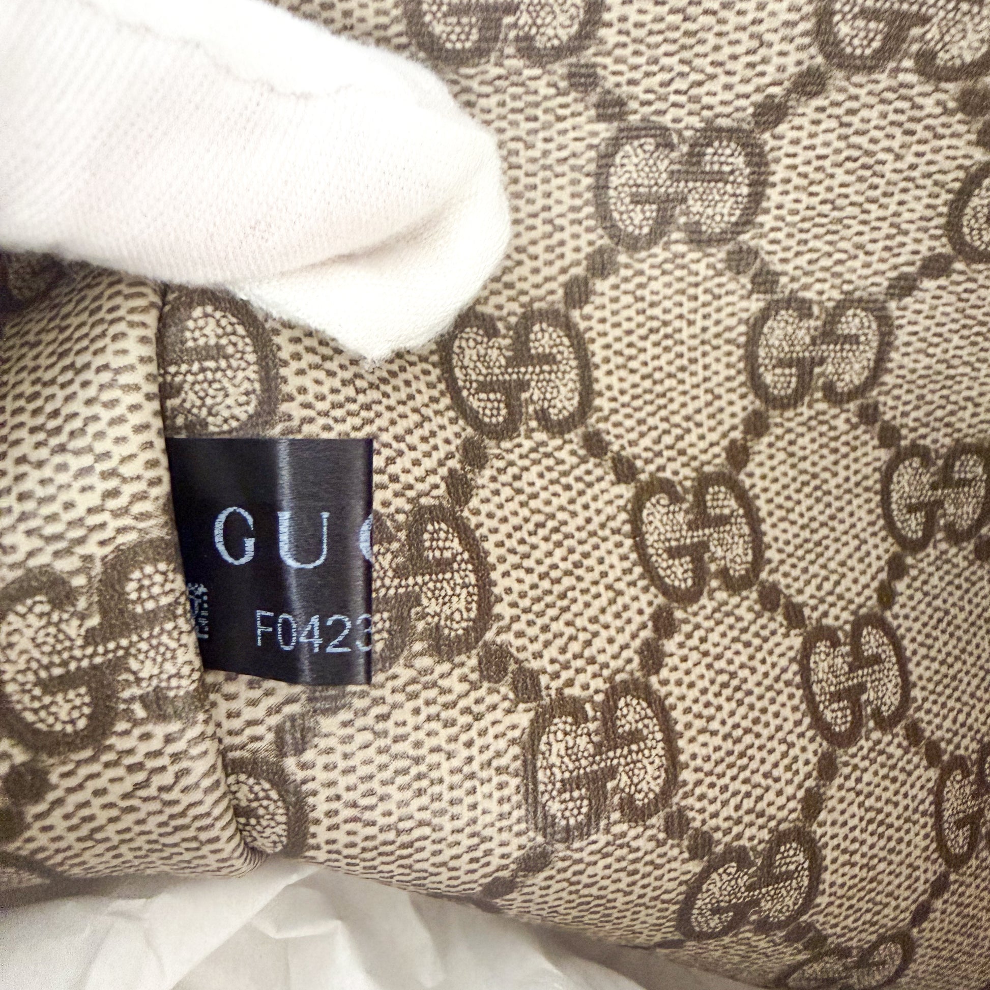 Unworn Gucci logo print tote corner detail showing fabric serial number