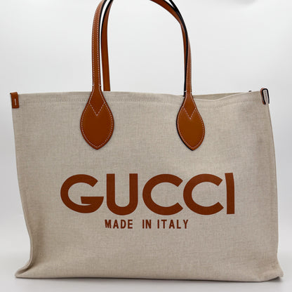 Brand new unworn Gucci logo print canvas tote front view with tan leather trim and GUCCI logo
