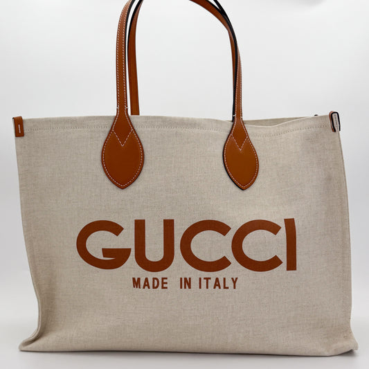 Brand new unworn Gucci logo print canvas tote front view with tan leather trim and GUCCI logo