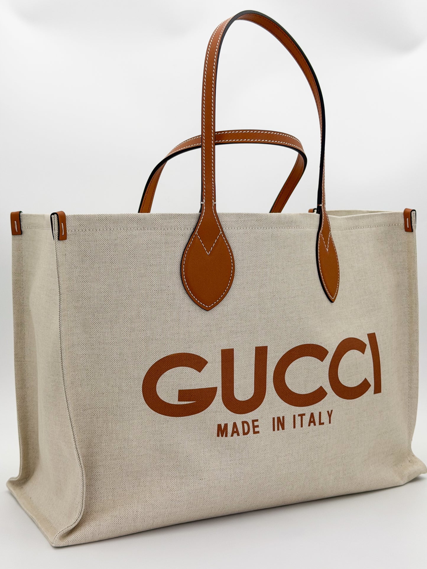 Brand new Gucci canvas tote back view showing natural canvas and leather handles