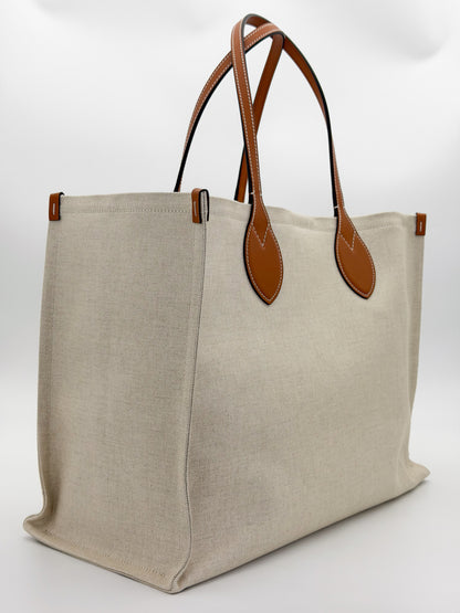 Brand new Gucci canvas tote side view showing natural canvas and leather handles