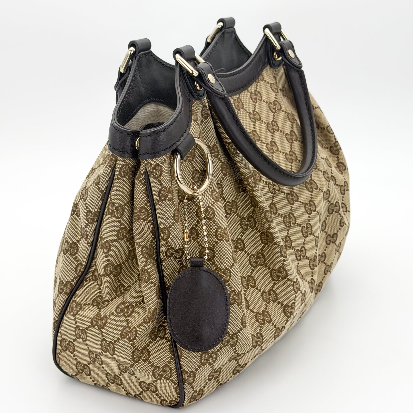 Gucci Sukey tote left side view showing pleated canvas and rolled handles
