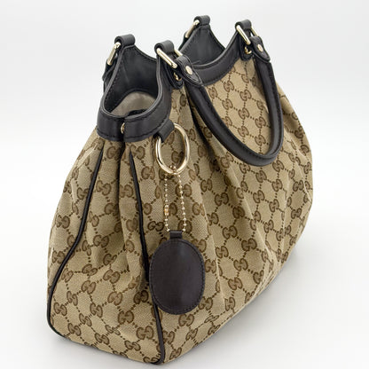 Gucci Sukey tote left side view showing pleated canvas and rolled handles
