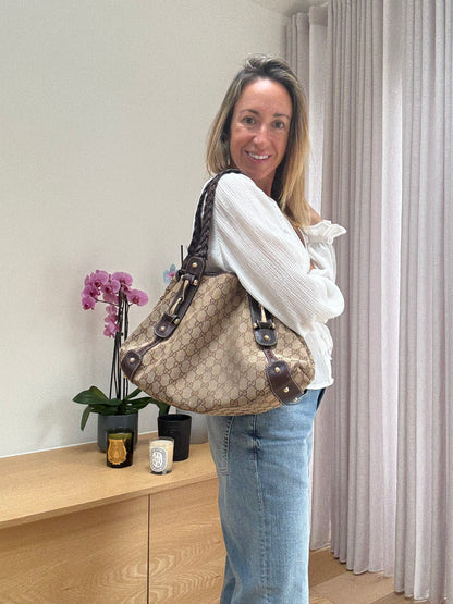 Gucci Pelham GG canvas horsebit shoulder bag worn on shoulder