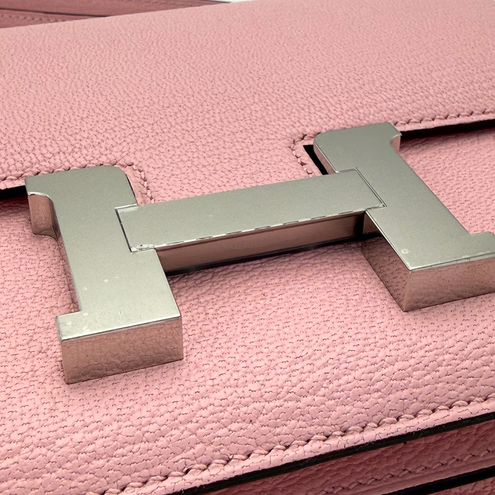 Hermès Constance 18 Rose Sakura Chèvre Mysore close up of palladium H closure clasp.