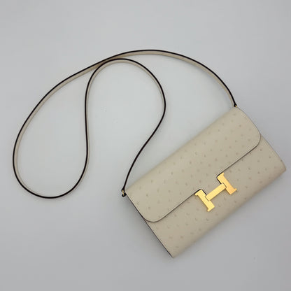 Ariel View of a brand new Hermès Constance To Go in Nata ostrich with gold hardware and the belt strap attached.