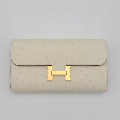 Front flat view of a brand new Hermès Constance To Go in Nata ostrich with gold hardware 
