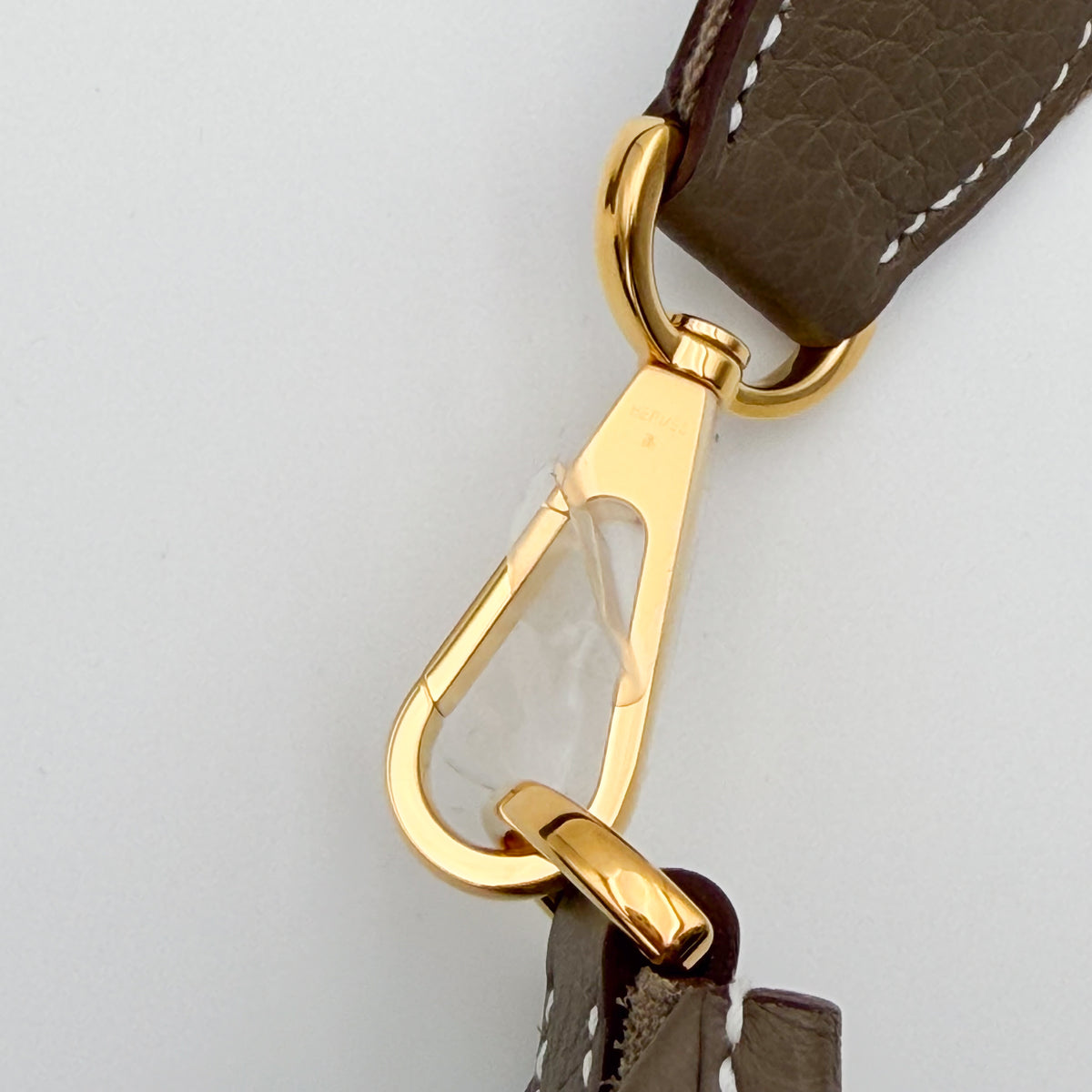 Gold swivel clasp hardware detail on Hermès Evelyne strap