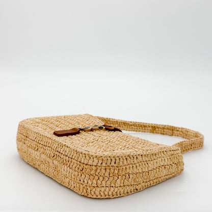 Saint Laurent raffia hobo bag angled side view showing tan leather strap detail