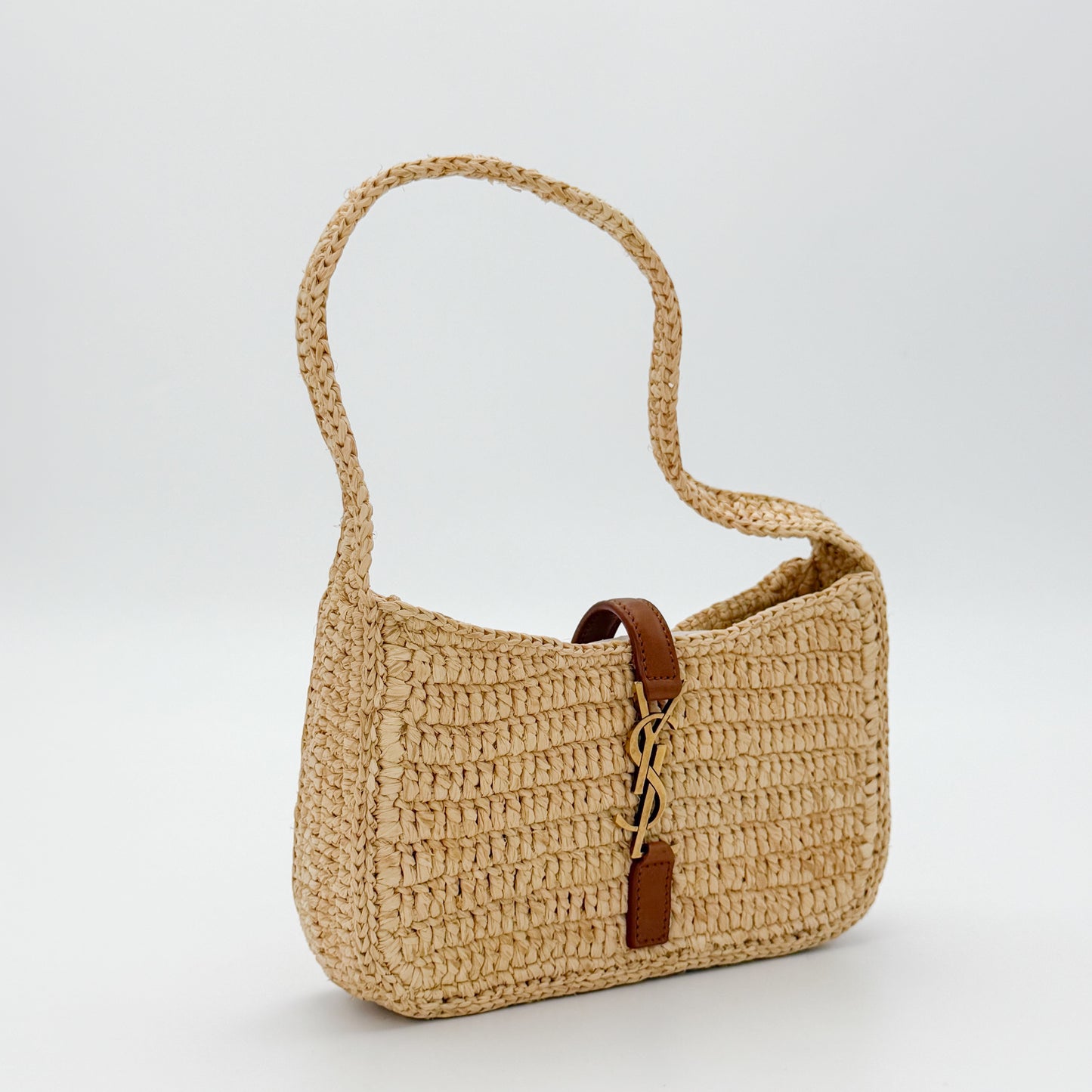 Vintage Saint Laurent raffia hobo bag angled side view showing tan leather strap detail