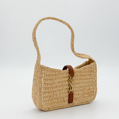 Vintage Saint Laurent raffia hobo bag angled side view showing tan leather strap detail